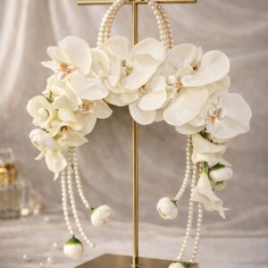 Luxury white orchid pearl cascade bouquet with flowing pearl strands displayed on a gold stand by EVAARAZ