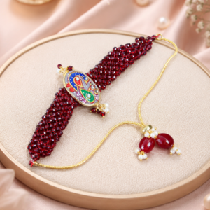 Traditional red beaded handmade rakhi with floral kundan centerpiece and artisan hand-painted detailing.